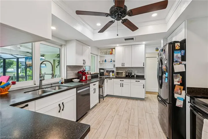 Kitchen featuring open shelves, stainless steel appliances, white cabinets, a ceiling fan, and plenty of natural light