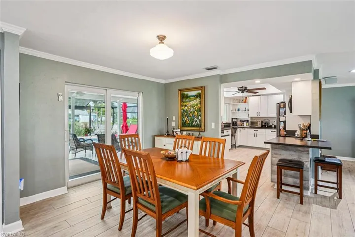 Dining area with ornamental molding, ceiling fan, and light wood finished floors