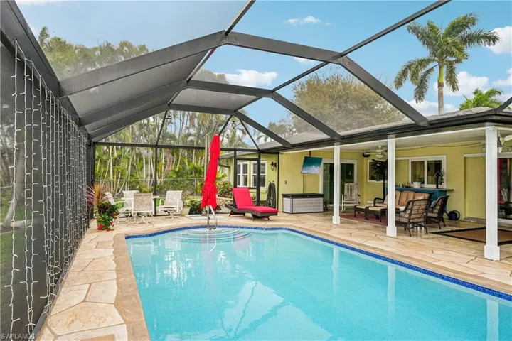 Swimming pool featuring outdoor lounge area, a sunroom, a patio, and a lanai
