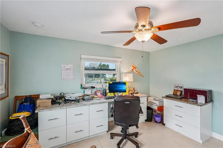 Office space with light tile patterned floors and ceiling fan