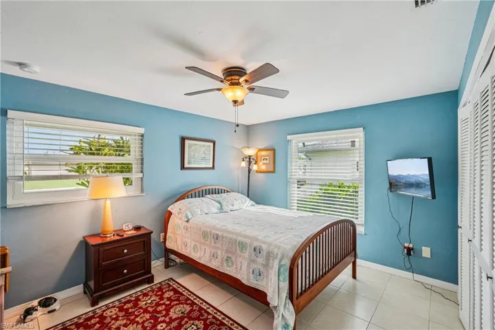 Bedroom featuring ceiling fan, light tile patterned floors, and a closet