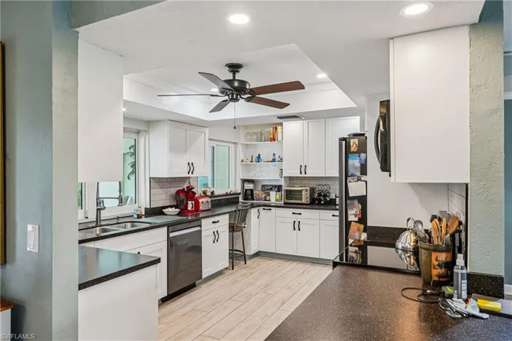 Kitchen featuring open shelves, ceiling fan, white cabinets, light wood-style flooring, and stainless steel appliances