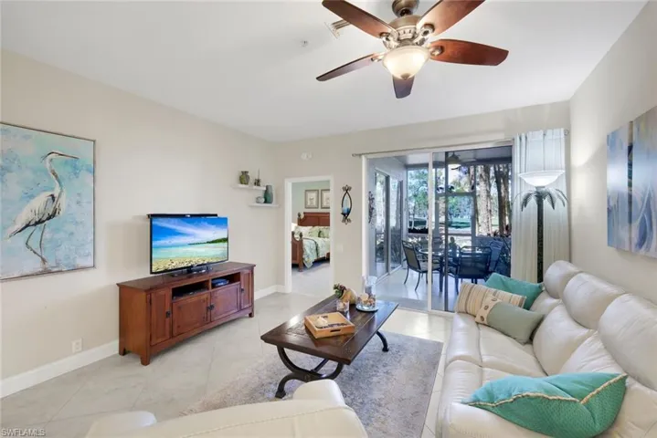 Living room with ceiling fan and light tile patterned flooring