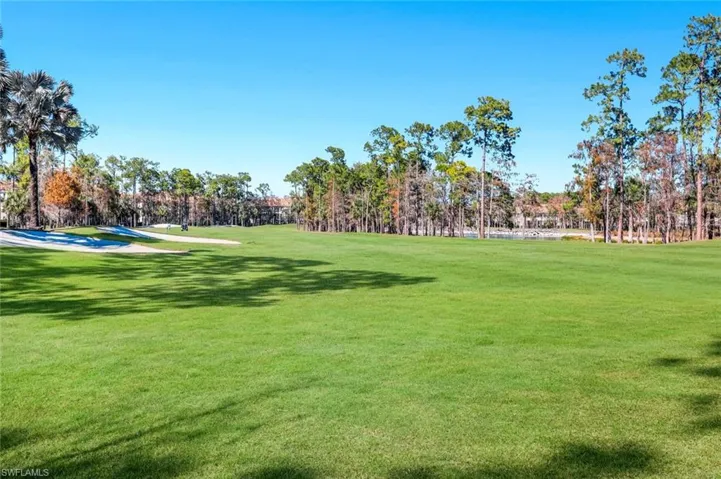 View of community with golf course view and view of wooded area