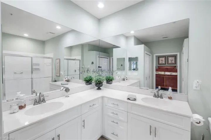 Full bath featuring a stall shower and double vanity