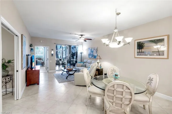 Dining space featuring a ceiling fan, suspended lighting, and light tile patterned flooring