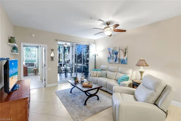 Living room featuring a ceiling fan and light tile patterned floors