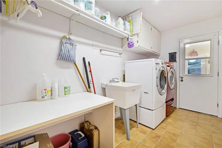 Laundry area featuring cabinet space, washing machine and clothes dryer, and light tile patterned floors