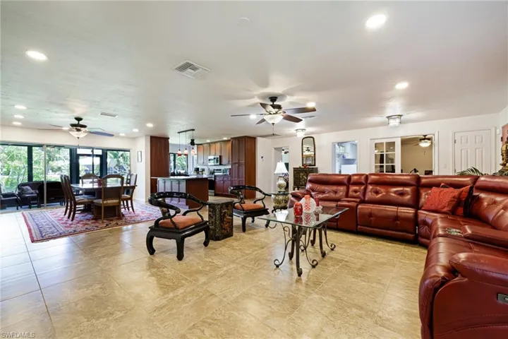 Living area with a ceiling fan, recessed lighting, and light tile patterned floors