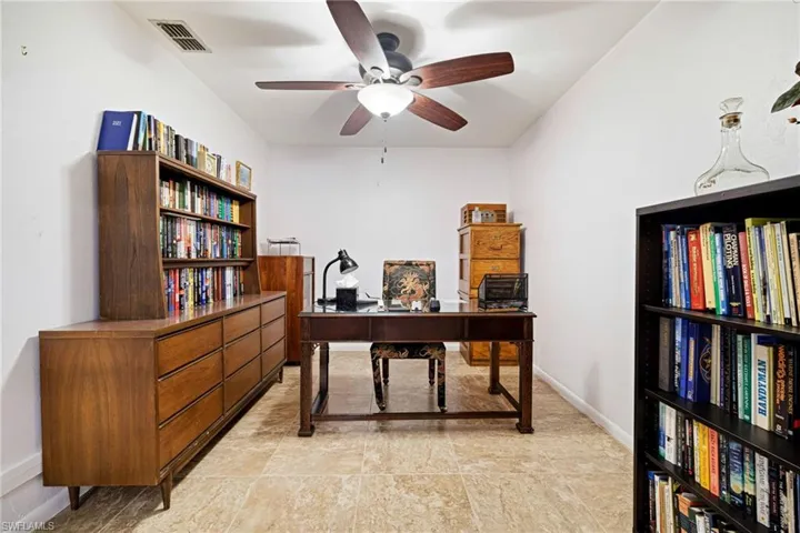 Office space featuring a ceiling fan and baseboards