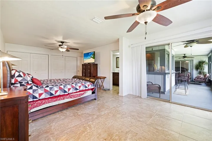 Bedroom with access to exterior, a ceiling fan, and two closets