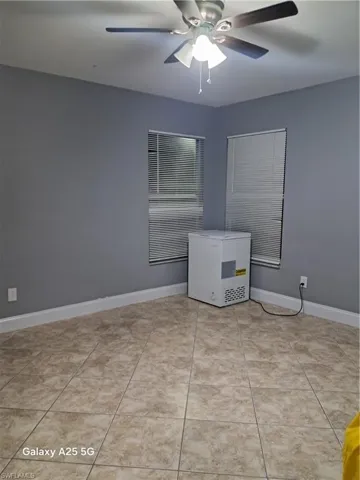 Tiled empty room with ceiling fan