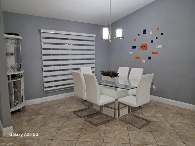 Dining room featuring light tile patterned flooring and a chandelier
