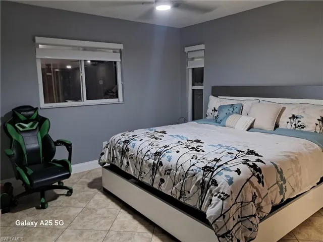 Bedroom featuring light tile patterned floors and ceiling fan
