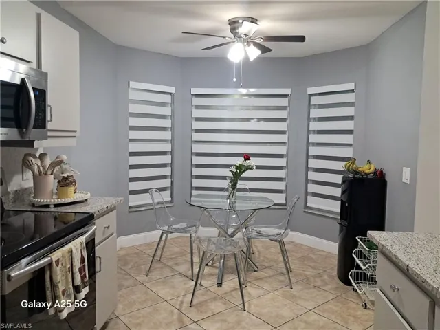 Tiled dining room featuring ceiling fan