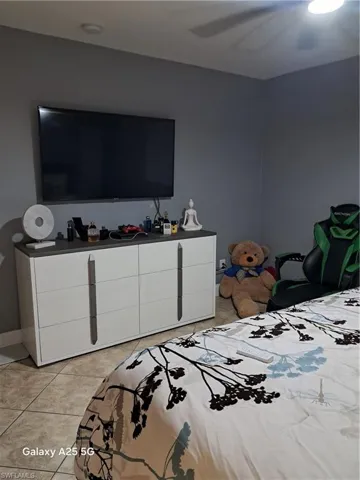 Bedroom with ceiling fan and light tile patterned floors