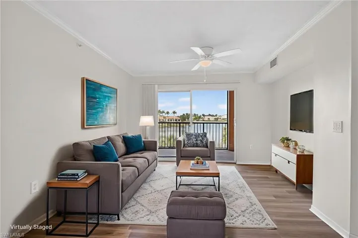 Great room with all new LVP floors, a ceiling fan, and ornamental molding