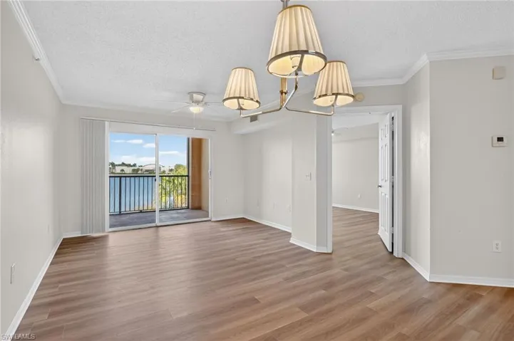 Great room and dining area with all new LVP floors throughout, ceiling fan, chandelier, and crown molding