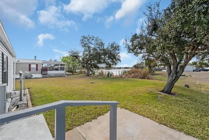 View of grassy yard with a sunroom