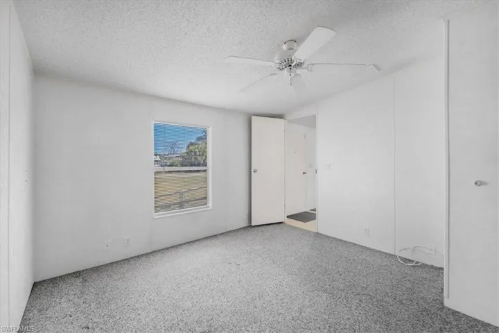 Spare room with ceiling fan, a textured ceiling, and dark speckled floor