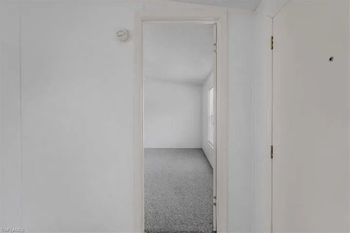 Hallway with carpet and a textured ceiling
