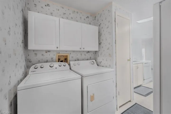 Laundry area featuring cabinet space, independent washer and dryer, and light floors