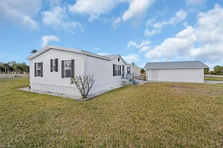 View of side of home with a yard and a wooden deck