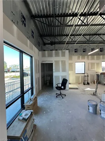 Misc room featuring concrete flooring and a high ceiling