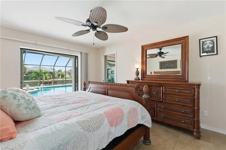 Bedroom with access to exterior, a sunroom, a ceiling fan, and light tile patterned floors