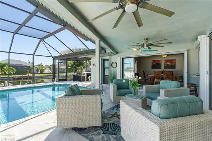 Swimming pool featuring a patio, a sunroom, outdoor lounge area, and glass enclosure