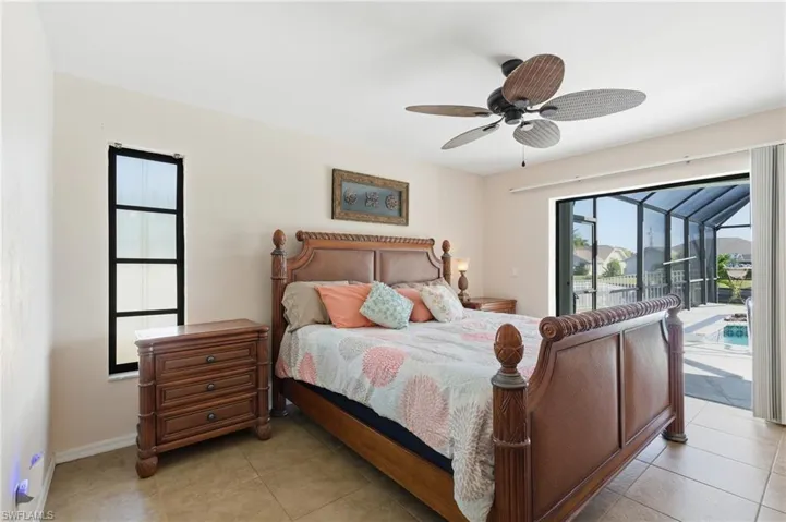Bedroom with a ceiling fan, access to exterior, and light tile patterned floors