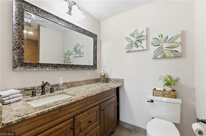 Half bathroom featuring vanity and light tile patterned floors