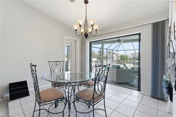 Dining room featuring a sunroom, plenty of natural light, light tile patterned floors, and vaulted ceiling