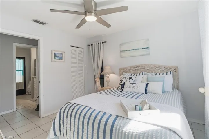 Bedroom with light tile patterned floors, a ceiling fan, and a closet