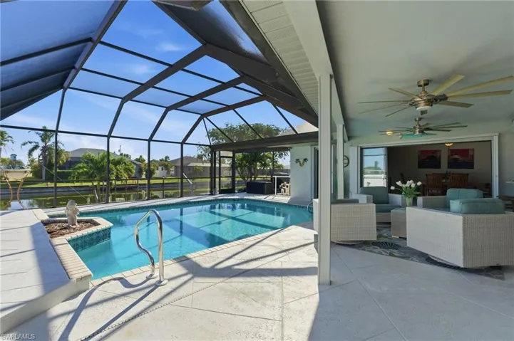 Swimming pool featuring a patio, an outdoor hangout area, a sunroom, and glass enclosure