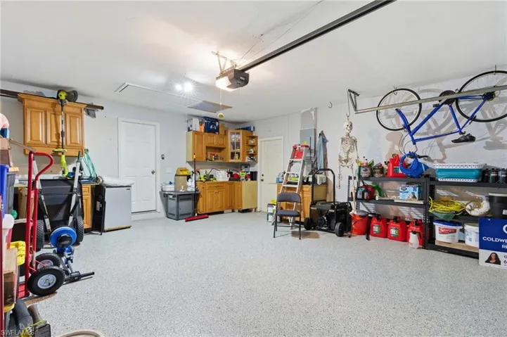 Garage featuring a garage door opener and refrigerator