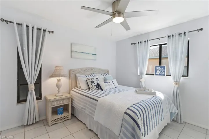 Bedroom with ceiling fan and light tile patterned flooring