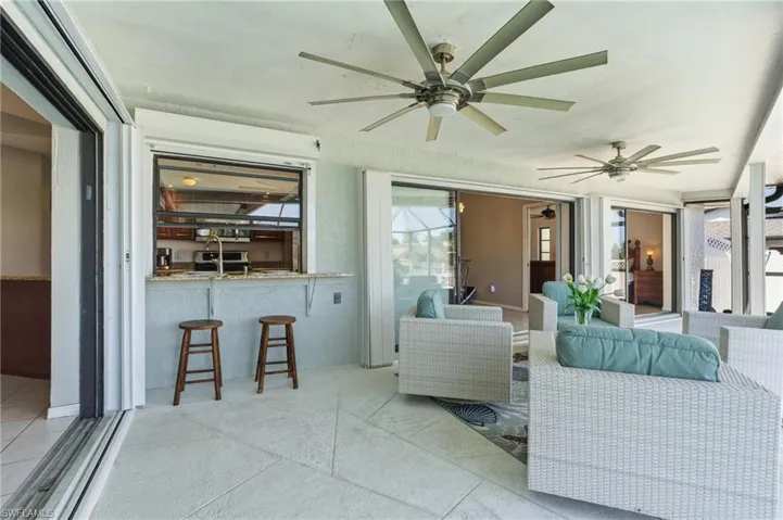 Sunroom / solarium with a ceiling fan, a patio, and an outdoor hangout area