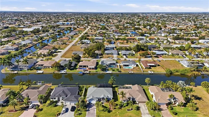 Aerial view of property and surrounding area featuring a large body of water and nearby suburban area