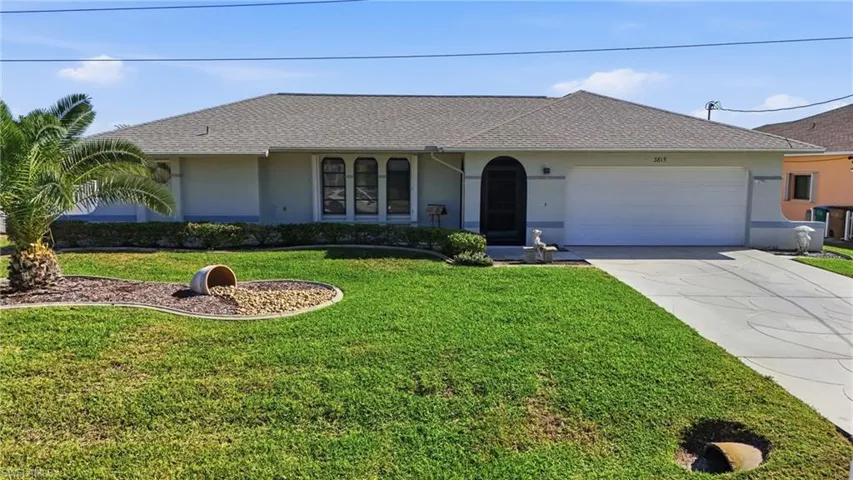 Ranch-style home with driveway, stucco siding, a front lawn, roof with shingles, and a garage