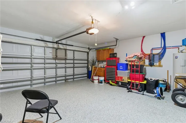Garage with electric water heater and a garage door opener