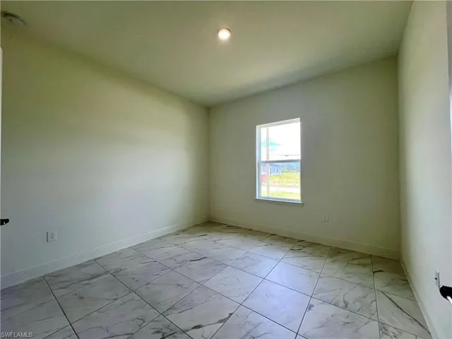 Unfurnished room with light marble finish floors and baseboards