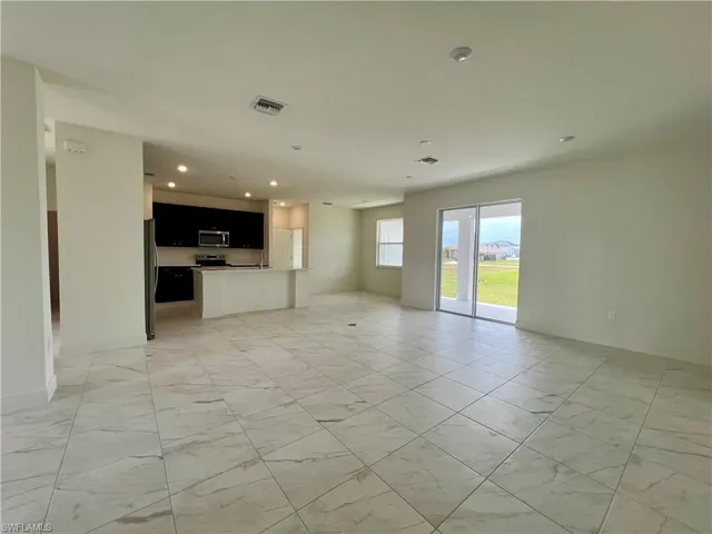 Unfurnished living room featuring recessed lighting and light marble finish flooring