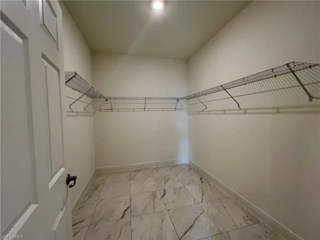 Spacious closet with light marble finish floors