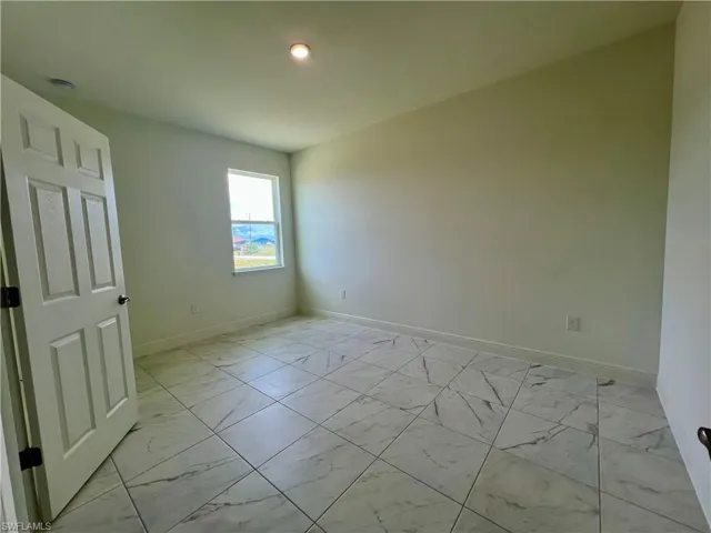 Spare room featuring light marble finish flooring