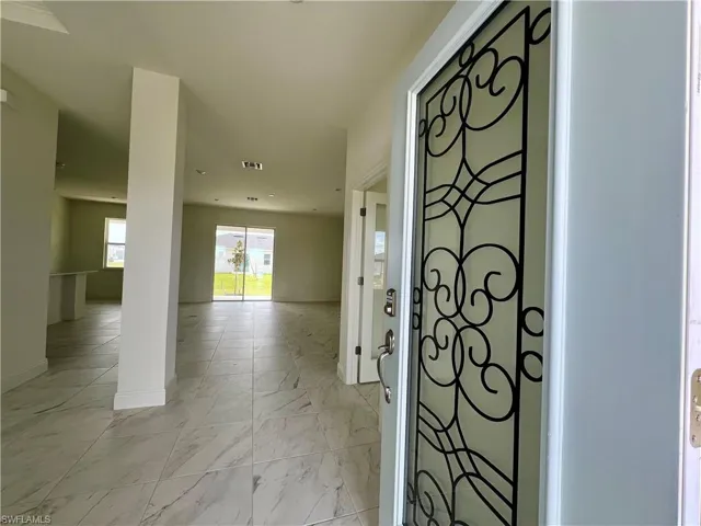 Foyer entrance with baseboards and light marble finish floors
