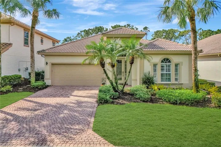 Mediterranean / spanish house featuring a front yard, decorative driveway, an attached garage, and stucco siding