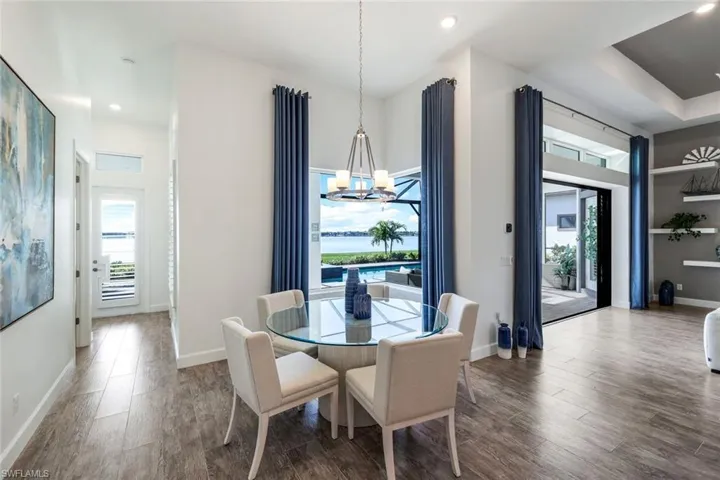 Dining space featuring a chandelier, wood finished floors, healthy amount of natural light, and recessed lighting