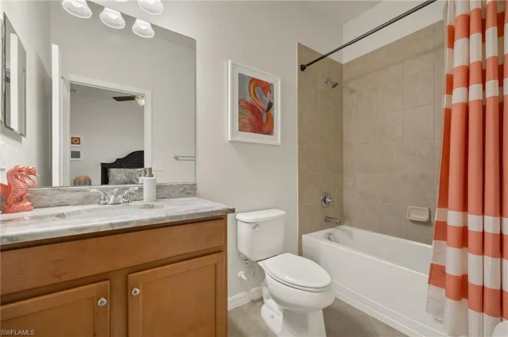 Full bathroom featuring vanity, tile patterned flooring, shower / bathtub combination with curtain, and toilet