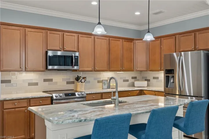 Kitchen with sink, a center island with sink, and appliances with stainless steel finishes